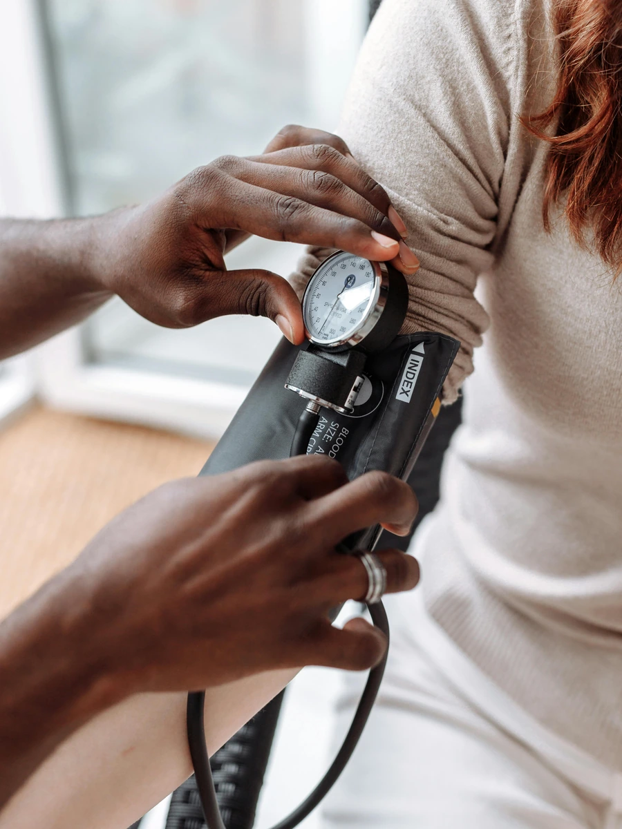 Healthcare professional checking blood pressure with a sphygmomanometer during a medication review